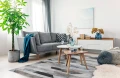 dywan-nowoczesny-dean-szary-aranazacja-w-salonie-na-jasnej-podlodze-z-jasna-sofa-i-stolikami-kawowymi.webp