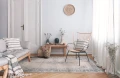 dywan-vintage-marylou-kremowy-aranzacja--w-salonie-na-jasnej-podlodze-z-jasnymi-scianami-sofa-i-stolikiem-pod-sciana-na-srodku-krzeslo.webp
