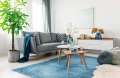 dywan-vintage-marylou-niebieski-aranzacja--w-salonie-na-jasnej-podlodze-z-jasnymi-scianami-stolikami-na-srodku-oraz-jasna-sofa.webp