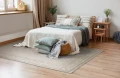 dywan-vintage-marylou-bezowy-aranzacja-w-sypialni-na-jasnej-podlodze-z-kremowa-narzuta-na-lozku-i-jasnymi-scianami.webp