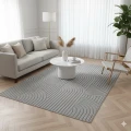 dywan-nowoczesny-3d-helix-geometria-szary-aranzacja-na-jasnej-podlodze-z-sofa-stolikiem-kawowy-krzeslem-jasnymi-scianami-oraz-dwoma-oknami-w-salonie.jpg.png