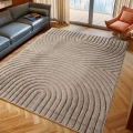dywan-nowoczesny-art-3d-geometria-bezowy-aranzacja-w-salonie-z-wygodnym-fotelem-i-duzym-oknem-w-tle-i-ciemna-sofa.jpg