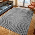 dywan-nowoczesny-art-3d-geometria-szary-aranzacja-na-parkiecie-z-ciemna-sofa-i-oknem-w-tle.jpg