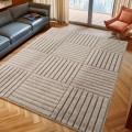 dywan-nowoczesny-art-3d-kwadraty-bezowy-aranzacja-w-salonie-na-ciemnej-podlodz-z-ciemna-sofa-i-oknem-w-tle.jpg