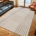 dywan-nowoczesny-art-3d-kwadraty-kremowy-aranzacja-w-salonie-na-ciemnej-podlodz-z-ciemna-sofa-i-oknem-w-tle.jpg