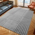 dywan-nowoczesny-art-3d-kwadraty-szary-aranzacja-w-salonie-na-ciemnej-podlodz-z-ciemna-sofa-i-oknem-w-tle.jpg