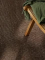dywan-wełniany-greenwich-ted-baker-brązowy-zbliżenie-z-brązowym-krzesłem-i-zielonym-kocem.jpg